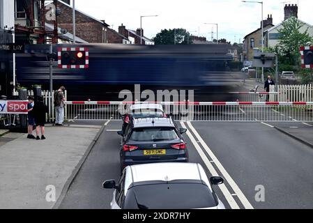 In tutto il Regno Unito - il treno merci accelera attraverso il passaggio a livello a Bamber Bridge, Lancashire, Regno Unito Foto Stock