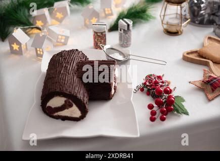 Una fetta di torta di Capodanno su un piatto, rivelando bellissimi strati di ripieno, condita da un affascinante uomo di pan di zenzero, incarnando l'eleganza festiva e la S Foto Stock