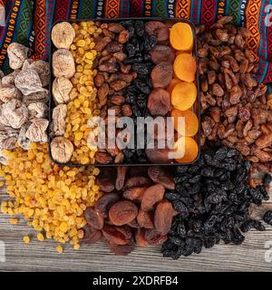 Tipi di frutta secca. Albicocche secche, uvetta nera e leggera e fichi secchi in una borsa regalo. Ci sono molti tipi di frutta secca nei mucchi sul tonno Foto Stock