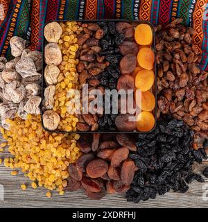 Tipi di frutta secca. Albicocche secche, uvetta nera e leggera e fichi secchi in una borsa regalo. Ci sono molti tipi di frutta secca nei mucchi sul tonno Foto Stock