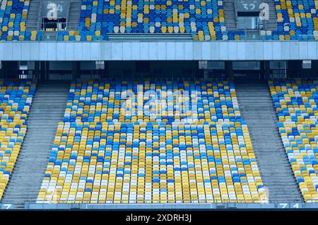 Stadio. Posti a sedere vuoti su tribune dipinte di blu e giallo. Foto Stock
