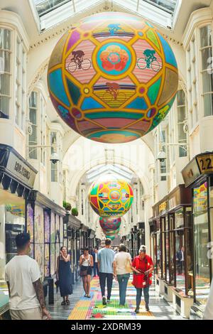 Londra, Regno Unito. 24 giugno 2024. Il Burlington Arcade, l'elegante e tradizionale galleria di negozi nel Mayfair di Londra, e' decorato con un corridore a tappeto lungo a tema 'Sporting Club' e palle giganti del globo, che presenta molte delle competizioni sportive estive, tra cui calcio, sport olimpici e, naturalmente, tennis. Crediti: Imageplotter/Alamy Live News Foto Stock