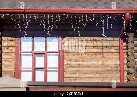 una casa in legno con una finestra e una serie di luci sul tetto Foto Stock