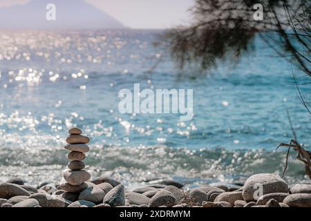 Le pietre si bilanciano sulla spiaggia, scatti al tramonto con sfondo sfocato Foto Stock