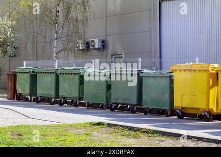 contenitori per la spazzatura sul muro di un edificio grigio Foto Stock