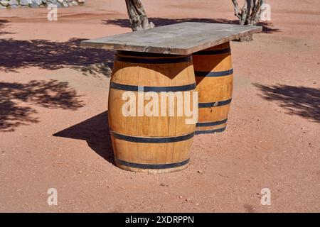 Vecchia botte di legno in fila con un tavolo in cima in un vigneto a Cafayate, Salta, Argentina Foto Stock