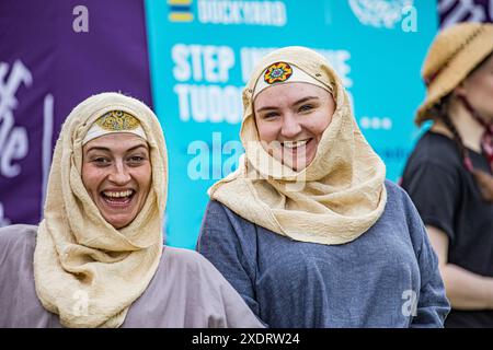 BROADCHALKE, WILTSHIRE, UK, 24 giugno 2024, due donne vestite con abiti vintage dell'epoca medievale, indossando tute e tuniche, sorridenti. Immagine catturata al Chalke History Festival, il più importante festival di storia del Regno Unito. Accreditamento John Rose/Alamy Live News Foto Stock