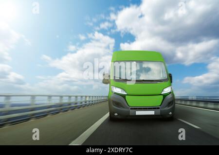 Furgone verde per la consegna di energia elettrica su un'autostrada. Concetto di flotta verde. Foto Stock
