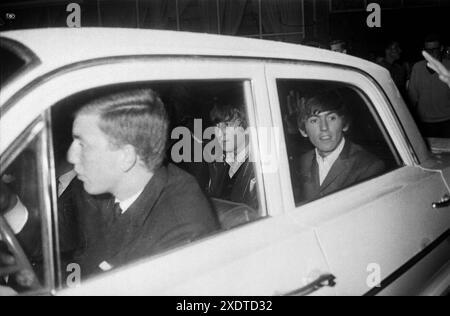 I Beatles in una macchina (John Lennon e George Harrison visibili) lasciano uno studio televisivo. Treslong, Paesi Bassi, Olanda. Giugno 1964 Foto Stock