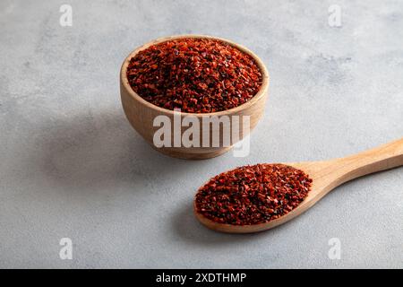 Peperoncino, peperoncino rosso in una ciotola di legno su sfondo azzurro Foto Stock