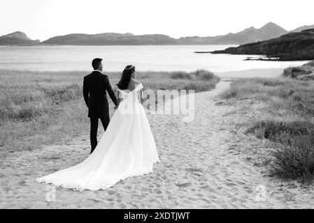Sposa e sposo che contemplano una spiaggia dopo il matrimonio Foto Stock