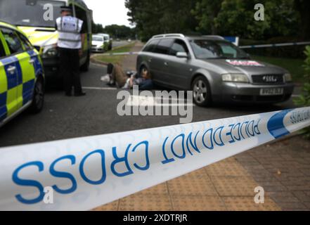 24 giugno 2024, Bristol, Inghilterra, Regno Unito: Attivisti, giacere sul pavimento bloccando la strada dietro un cordone della polizia fuori Elbit Systems a Bristol. I sostenitori di Palestine Action usano le chiuse per bloccare l'unico accesso veicolare alla compagnia di difesa israeliana, l'attività di Elbit Systems ad Aztec West, Bristol. Essi sostengono che le armi prodotte da Elbit nel Regno Unito sono usate dagli israeliani contro i palestinesi a Gaza e altrove. I bombardamenti israeliani a Gaza hanno ucciso oltre 35.000 palestinesi dall'ottobre 2023. Palestina Action è determinata a prendere di mira senza sosta Elbit e le loro società partner direttamente Foto Stock