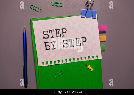 Testo concept Step by Step scritto su blocchi di legno su sfondo scuro Foto Stock