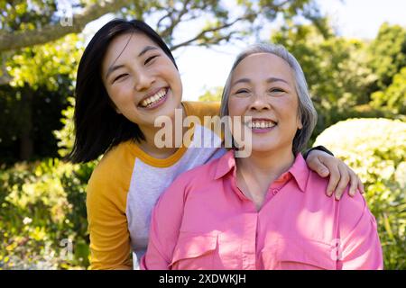 Mamma e figlia sorridono insieme all'aperto, godendo del tempo libero in famiglia Foto Stock