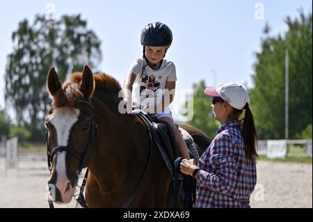 Non esclusiva: LEOPOLI, UCRAINA - 21 GIUGNO 2024 - Un ragazzo viene portato a cavallo sul territorio della struttura dove si svolge un allenamento equestre aperto Foto Stock