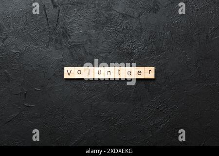Volunteer parola scritta sul blocco di legno. volontario del testo in tabella, concetto. Foto Stock