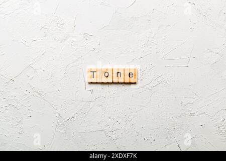 tono parola scritta su blocco di legno. tono testo su tabella di cemento per il vostro desing, concetto. Foto Stock