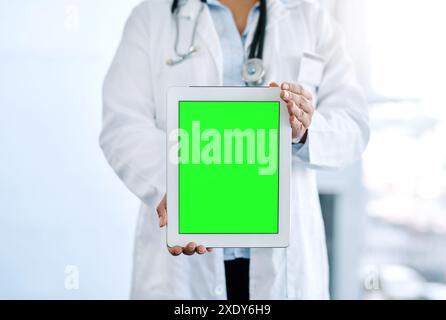 Schermo verde, tablet e mani del medico in ospedale con ricerca medica, telemedicina e assistenza. Persona, mockup e farmacista con consigli e. Foto Stock