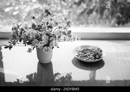 Bouquet di trifoglio nella tazza sul tavolo alla finestra Foto Stock