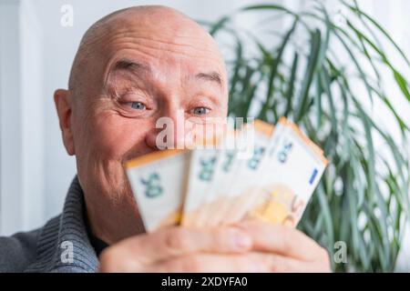 uomo soddisfatto in possesso di euro, euro in tifoso, gioisce del successo, anticipa su cosa spenderlo, incoraggiando un buon comportamento finanziario, aw economico Foto Stock