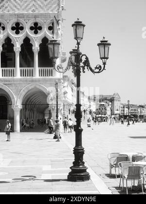 Venezia, Italia - 30 giugno 20220 immagine in bianco e nero di un lampione decorato in una piazza con persone che camminano sullo sfondo Foto Stock