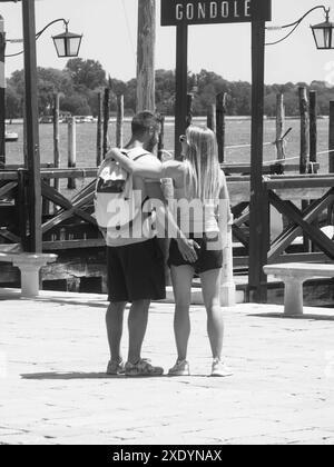 Venezia, Italia - 30 giugno 20220 la giovane coppia si sta abbracciando vicino a una stazione della gondola a venezia, italia, godendo la loro fuga romantica Foto Stock