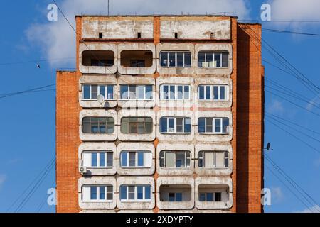 Tipico edificio residenziale a torre in cemento e mattoni di media russia, su sfondo blu del cielo Foto Stock