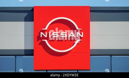 Nissan. Un cartellone rosso con il logo Nissan su sfondo blu cielo. Foto Stock