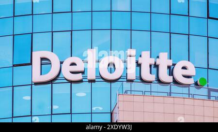 Deloitte segno sulla facciata di vetro di un edificio di uffici Foto Stock