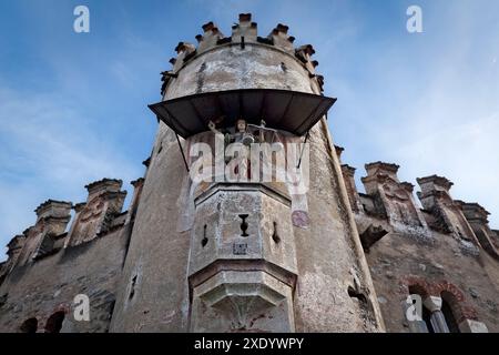 Abbazia di Novacella: Torre cilindrica con scultura del Castello dell'Angelo romanico e fiori di tulipani. Varna, alto Adige, Italia. Foto Stock