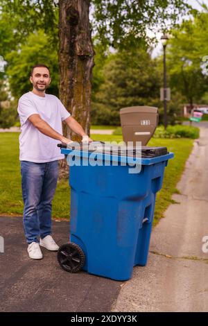 L'uomo caucasico sta gettando via due sacchi di plastica della spazzatura vicino alla sua casa. Foto Stock