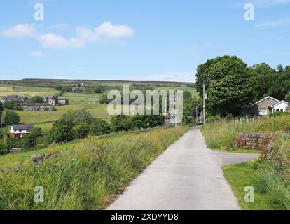 Stretto vicolo di campagna con il villaggio di Wadworth e i campi collinari vicino al ponte hebden a calderdale, nello yorkshire occidentale Foto Stock