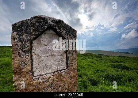 Pietra religiosa con bassorilievo tra i pascoli della Lessinia. Velo Veronese, Veneto, Italia. Foto Stock