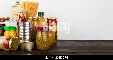 Cibo di sopravvivenza di emergenza impostato su tavolo da cucina di legno scuro Foto Stock