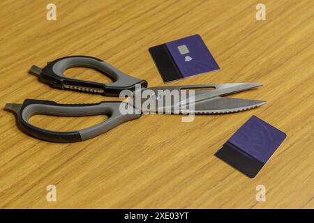 Tagliare la carta di credito accanto alle forbici su un tavolo. Foto Stock