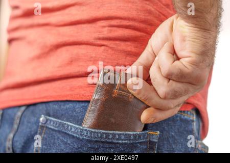 Uomo che tiene il suo vecchio portafoglio in pelle nella tasca dei jeans Foto Stock