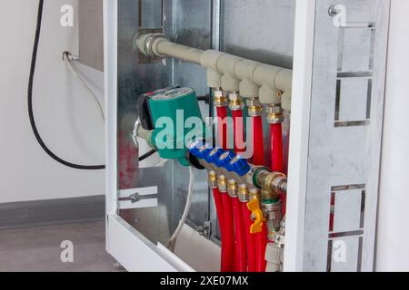 Collettore per rubinetti di riscaldamento. Armadio per la regolazione del riscaldamento a pavimento. Foto Stock