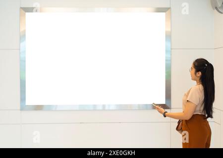Poster orizzontale di grandi dimensioni vuoto in luoghi pubblici. Un cartello mockup vicino alla scala mobile nell'edificio dell'aeroporto, nell'edificio degli uffici o nella stazione della metropolitana. Visualizzazione 3D. Foto Stock
