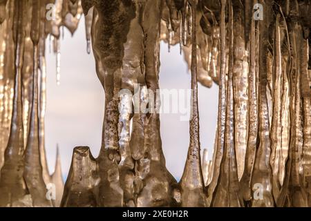 Ghiaccioli in grotta sul lago Baikal al tramonto Foto Stock