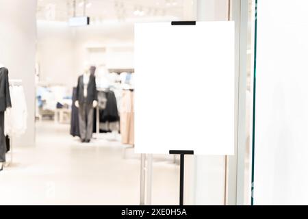 Negozio di abbigliamento firmato nel centro commerciale. Cartello bianco verticale sulla parte anteriore di un negozio di abbigliamento con una finestra di vetro. Foto Stock
