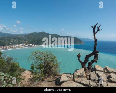 Vista aerea panoramica sul villaggio di Riva Trigoso da Torre Saracena a Punta Manara con rocce e alberi secchi in primo piano, case, cantiere navale e due Foto Stock