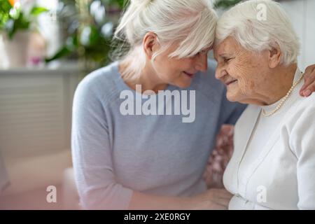 Felice donna anziana con sua figlia adulta a casa Foto Stock