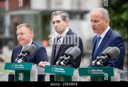 (Sinistra-destra) il ministro delle Finanze Michael McGrath, il Taoiseach Simon Harris e Tanaiste Micheal Martin durante l'annuncio agli edifici governativi di Dublino, che McGrath sarà nominato prossimo Commissario europeo dell'Irlanda. Data foto: Martedì 25 giugno 2024. Foto Stock