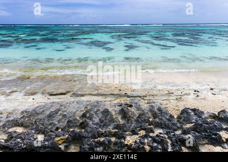 Scogli neri appuntiti sulla costa dell'isola di la Digue, vista spiaggia di Anse Union. Paesaggio costiero delle Seychelles Foto Stock