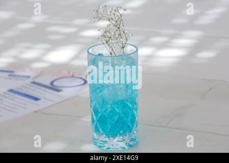 Blue Lagoon cocktail, Angelo azzurro cocktail in alto bicchiere sul tavolo del bar sulla spiaggia Foto Stock