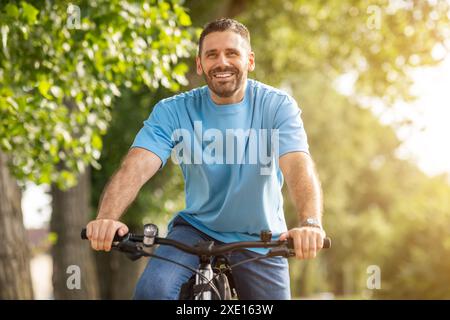 Happy Man in bicicletta nella soleggiata giornata estiva a Park Foto Stock