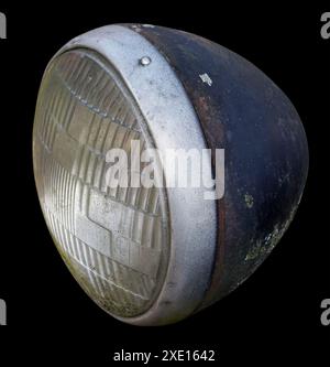 Faro rotto di un veicolo d'epoca isolato sul nero Foto Stock
