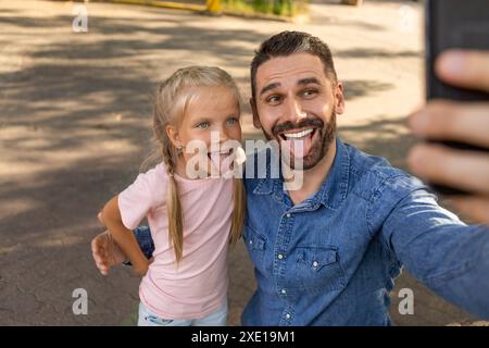 Padre e figlia portano Selfie divertente all'aperto Foto Stock