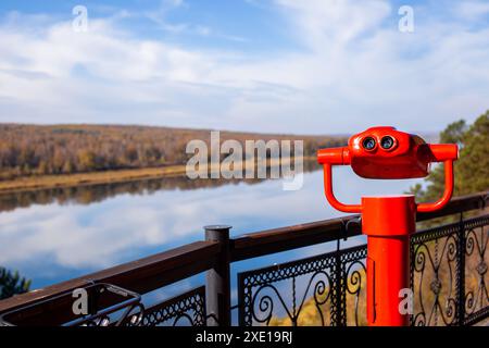 Binocolo pubblico stazionario sulle rive del fiume in estate Foto Stock