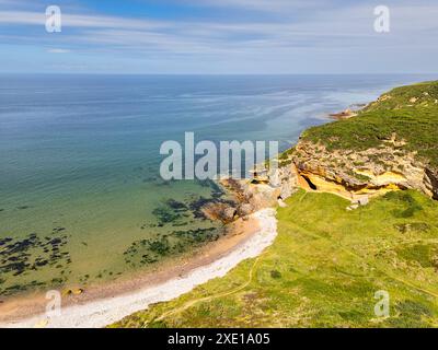 Costa di Hopeman Moray Firth, piccola insenatura scozzese e spiaggia con scogliera di arenaria dorata e mare verde blu Foto Stock